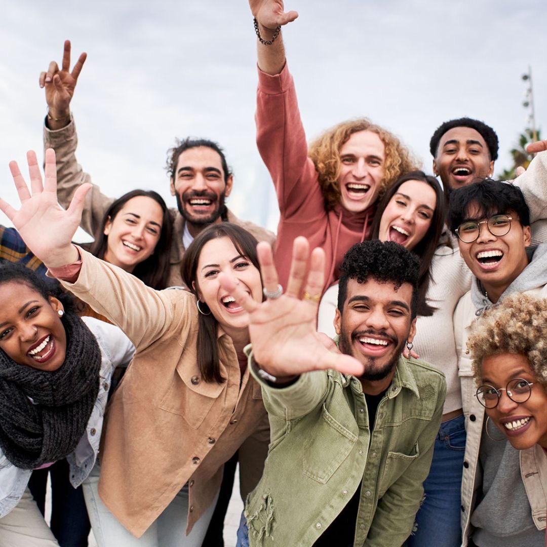 Diverse group of young people celebrating together, representing the youth empowerment mission of Uplifters